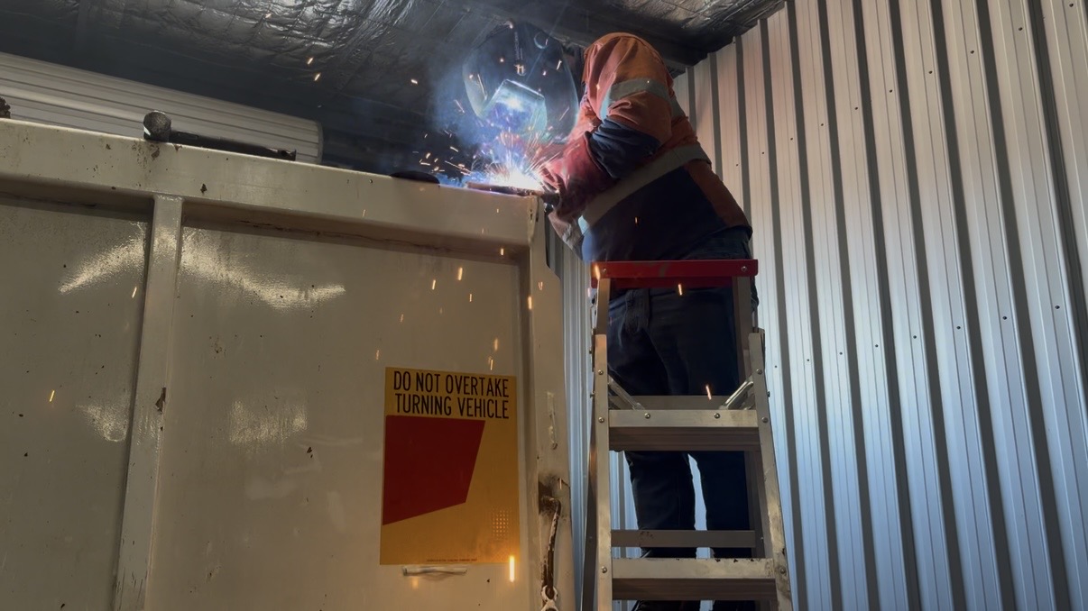 Welder working on a truck body in the shop